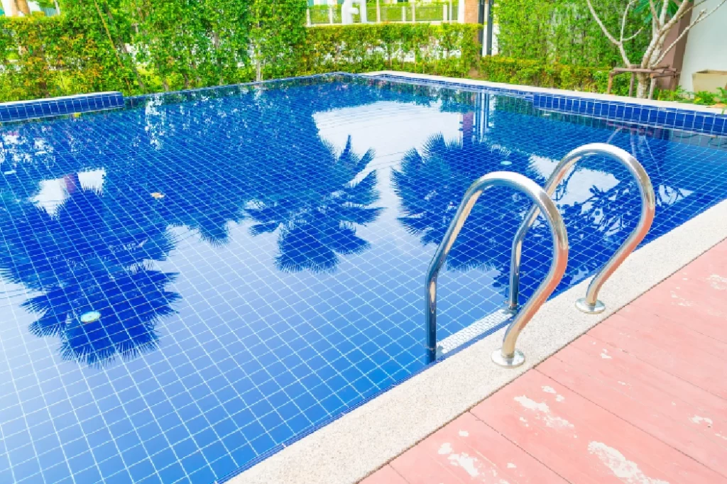 Ozonated swimming pool with crystal-clear blue water and stainless steel ladder, offering a safe and chemical-free swim.